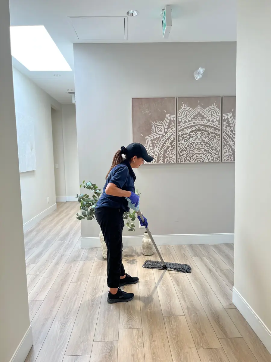 Office Care Pro team member mopping a commercial hallway floor