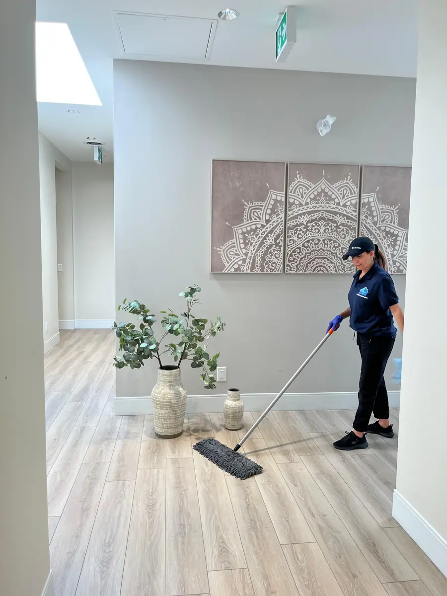 Office Care Pro cleaner mopping a commercial hallway