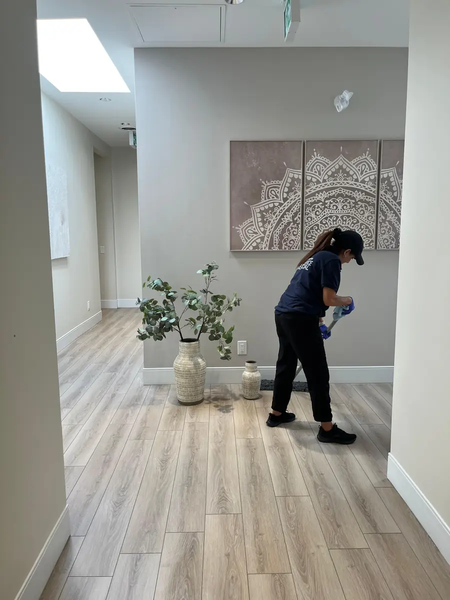 A member of the Office Care Pro crew wiping surfaces on site